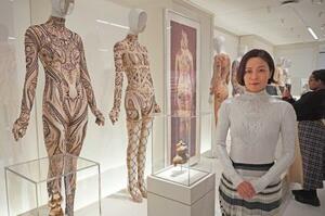 「コスチューム・アート展」で、自らの作品(左2点)のそばに立つ廣川玉枝さん=4日、米ニューヨークのメトロポリタン美術館(共同)