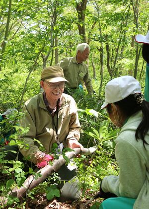 小学生と一緒に低木の伐採や下草刈りをしながら里山の魅力を伝える「妙高里山保全クラブ」の沖川庄平会長(左)=妙高市関山