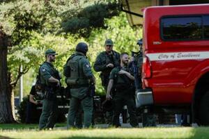 29日、米アイダホ州コーダリーンで消防士らが銃撃された現場近くに集まった捜査当局者(ロイター=共同)
