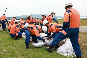 水防工法の訓練に取り組む消防団員たち=村上市の荒川河川敷