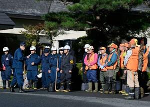クマに襲われたとみられる従業員が行方不明になった温泉旅館「瀬美温泉」で、捜索の準備をする警察官と猟友会のメンバー=17日午前、岩手県北上市
