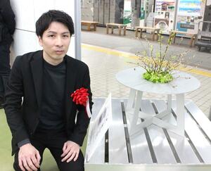 受賞作と並び、グランプリを喜ぶ植野靖隆さん=JR燕三条駅