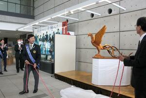 木彫りのフェニックス像をお披露目する分水ロータリークラブの町田健尚会長(左)。右は鈴木力市長=燕市役所