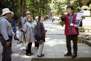 弥彦神社を案内する弥彦観光ぼらんてぃあガイド（弥彦観光協会提供）