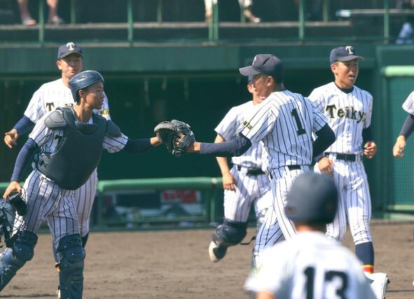 関根学園-帝京長岡 関根学園に完封勝利し、捕手の有馬凛空とグラブを合わせる帝京長岡の茨木佑太(背番号1)=長岡市悠久山球場