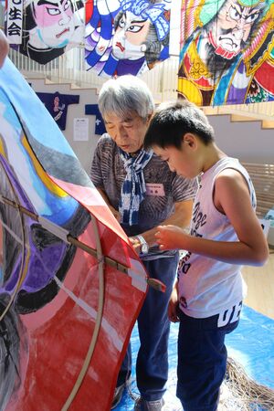 地元ボランティアに教わりながら大凧作りに挑戦する子ども=新潟市南区上下諏訪木