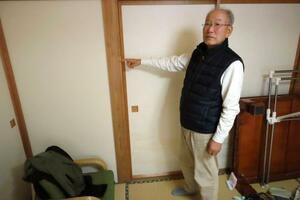 　２０１９年の台風１９号で浸水した高さを示す佐藤吉春さん＝１１日、長野市豊野地区