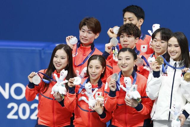 団体で銀メダルを獲得し記念撮影する（前列左から）吉田唄菜、三浦璃来、坂本花織、（中列左から）森田真沙也、佐藤駿、鍵山優真。奥は木原龍一＝ミラノ（共同）