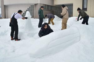 雪像作りに挑む国際大の留学生ら=南魚沼市国際町