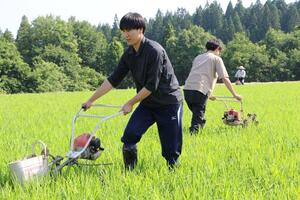 農家に泊まり溝切りを体験する麒麟山米づくり大学の受講者=阿賀町日野川甲