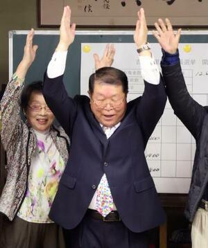 万歳する伊東健吾氏=12日夜、佐賀県吉野ケ里町