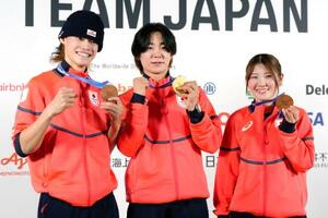 記者会見でメダルを掲げるスノーボード・ハーフパイプの(左から)山田琉聖、戸塚優斗、小野光希=15日、イタリア・ミラノ(共同)