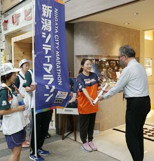 新潟シティマラソンのポスターを配布し、PRした大島めぐみさん(中央)ら=7月7日、新潟市中央区古町通6