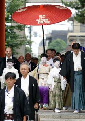 　京都・祇園祭の無事を祈願する「お千度の儀」で、八坂神社を参拝する稚児の長谷航太郎さん（中央）ら＝１日午前、京都市東山区