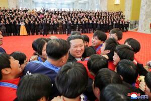 　サッカーのＵ―１７女子ワールドカップで優勝した北朝鮮の選手や監督らをねぎらう金正恩朝鮮労働党総書記（中央）＝２７日、平壌の万寿台議事堂（朝鮮中央通信＝共同）