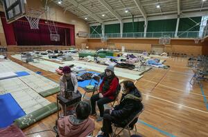 能登半島地震で被災し、避難所の体育館でストーブを囲む女性たち=1月7日、石川県七尾市
