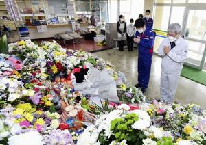 　北海道斜里町内の献花台で手を合わせる馬場隆町長（右、当時）ら＝２０２２年５月