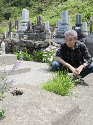 凱旋門の土台跡を見つめる髙村志津夫さん。「子どもの頃は、黄色だった記憶がある」と話す=佐渡市戸地
