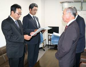県農業再生協議会の石山章会長(手前右)に緊急要請を行う県農業経営者協会の吉原幸夫会長(手前左)=15日、新潟市中央区