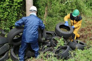 山積みに不法投棄された廃タイヤの撤去作業=聖籠町大夫興野