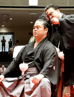 引退相撲の断髪式で師匠の境川親方に最後のはさみを入れられる元関脇妙義龍の振分親方=5日、両国国技館
