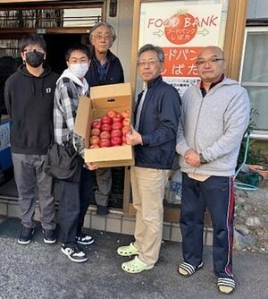 リンゴなどを贈呈する西新発田高校の社会科部員ら＝新発田市本町３