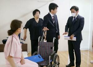 特別養護老人ホーム「サンシティ北条」で、介護の取り組みについて説明を受ける福岡厚労相(右端)=16日午後、松山市
