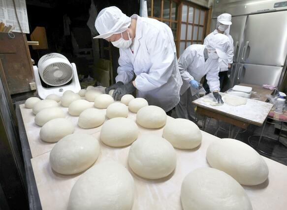 手作業で丁寧に丸められる鏡餅=28日、新潟市中央区の笹川餅屋