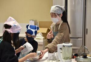 自身が企画したイベントで調理を手伝う澤田明歩さん(右)=長岡市美沢3