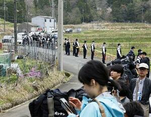 安達結希さんの自宅付近に集まった報道陣と、警戒にあたる警察官=15日、京都府南丹市