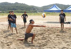 中越高校男子バレーボール部の生徒を指導するビーチバレーボール選手の長谷川徳海さん=8月24日、長岡市寺泊地域の海水浴場