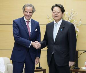 IAEAのグロッシ事務局長(左)と握手する林官房長官=3月12日午後、首相官邸