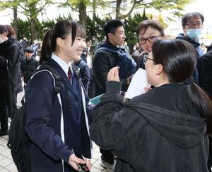 合格が決まり友人や家族らと喜びを分かち合う受験生＝１２日、新潟市中央区の新潟南高