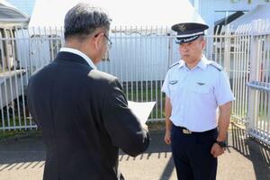航空自衛隊新田原基地の担当者に申し入れをする宮崎県の岩切達哉県議(手前)=1日午後、新富町