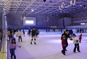 イルミネーションに彩られたリンクを楽しむ来場者たち=1月12日、新潟市中央区