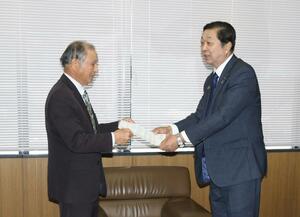 県農業再生協議会の石山章会長(左)に要請を行うJA県中の伊藤能徳会長=15日、新潟市中央区