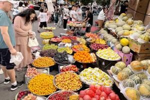 中国新疆ウイグル自治区ウルムチ市の露店に並ぶ多くの果物=7月(共同)