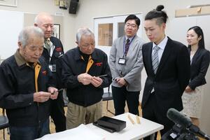 鍛冶職人研修の修了式で自身が製作したカミソリを紹介する稲垣良博さん(右から2人目)=三条市元町