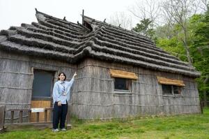 　復元されたチセ（家屋）を説明するシン・ウォンジさん