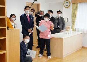 　「産後ケア」の事業に取り組む東京都内の施設を視察する自民党の小林政調会長（左後方から２人目）＝２７日午前