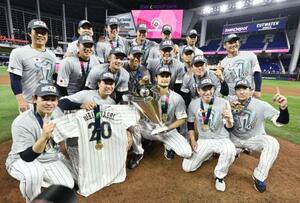 　２０２３年３月、ＷＢＣで優勝し、トロフィーを手にしたダルビッシュを中心に記念写真に納まる投手陣ら＝マイアミ（共同）
