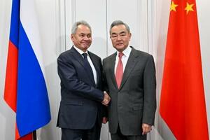 　ロシアのショイグ安全保障会議書記（左）と握手する中国の王毅外相＝２日、モスクワ（新華社＝共同）
