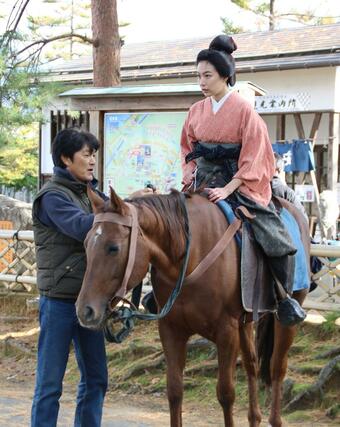 馬に乗るシーンの撮影を前に指導を受ける木竜麻生さん=新発田市