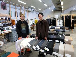 　尾州の生地や服が並ぶ「新見本工場」。宮浦晋哉さん（左）と彦坂雄大さん＝愛知県一宮市
