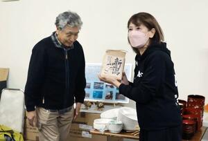 佐渡市内の農家有志が集めた米を受け取った輪島市の海女漁保存振興会の関係者=佐渡市加茂歌代