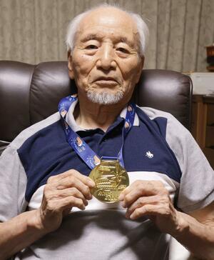 卓球の世界マスターズ選手権の優勝メダルを手にする増田和雄さん=新発田市本町1