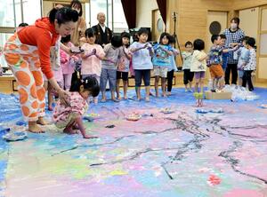 画家の野口佳代さんと作品を制作する明照幼稚園の園児たち=上越市寺町3