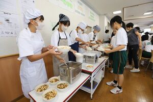 おかずを盛り付ける宮浦中の生徒ら=25日、新潟市中央区万代5