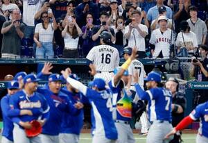 　９回、遊飛に倒れて最後の打者となった大谷（１６）。手前は日本に勝利し喜ぶベネズエラの選手たち＝マイアミ（共同）