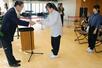 日本精機の佐藤浩一会長(左)から認定証を受け取る三条市立大学4年の本田彩音さん(中央)、對馬彩七さん(右)=三条市上須頃